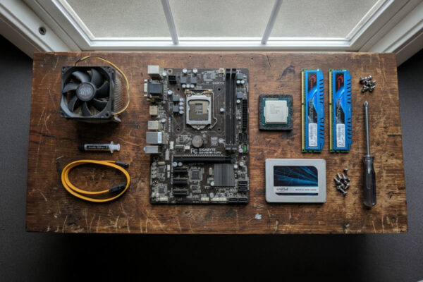 Motherboard, CPU cooler, RAM and SSD laid out on a workbench to build an affordable refurbished workstation